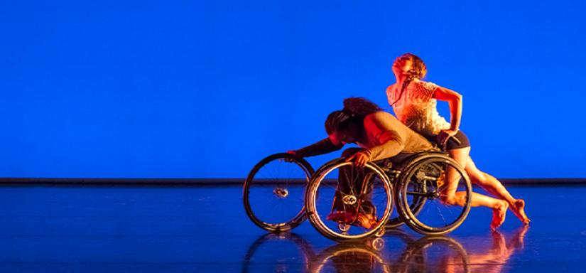 Deux danseuses autour d'un fauteuil roulant